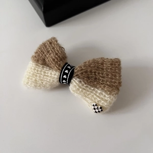 Pince à cheveux nœud tricoté bicolore avec cœur à damier sur fond blanc minimaliste