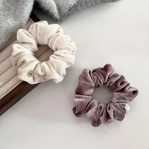 Premium soft velvet scrunchies in cream and mauve colors with elegant silver metal tags
