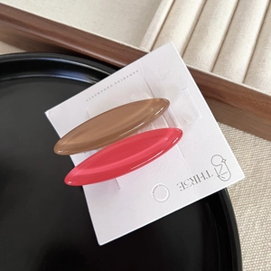 Detailed macro view of two oval candy-colored hair clips with a smooth marble finish