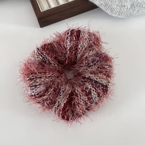 Dettaglio dell'elastico scrunchie in maglia soffice rosso e viola con filato morbido
