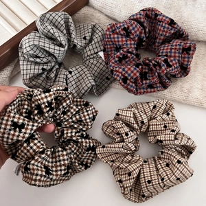 Close-up of vintage checkered hair scrunchies set with small bows in warm autumn tones
