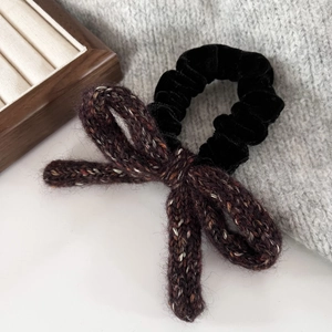 Close-up of velvet scrunchie and vintage knit bow texture for autumn hair styling