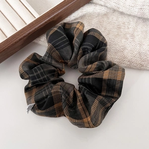 Close-up of vintage brown and black plaid scrunchie with soft fabric pleats for hair