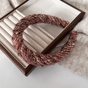 Detail of colorful woven thick headband with rich fiber texture on wooden box display