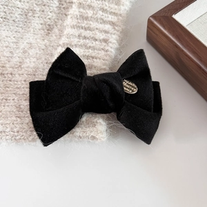 Eleganter schwarzer Samt-Haarclip mit goldener Metallplatte im minimalistischen Stil