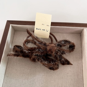 Detail of chocolate brown leopard faux fur bow hair tie with shimmering silver glitter thread