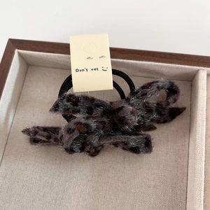 Macro detail of plush leopard print bow scrunchie with high elastic hair tie