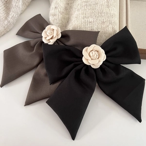 Gros plan sur une pince à cheveux nœud géant élégante avec fleur de camélia