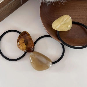 Detailed macro view of resin marble pendants on durable elastic hair bands in three colors