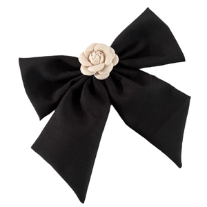 Barrette à cheveux avec grand nœud noir élégant et fleur de camélia sur fond blanc