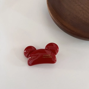 Nahaufnahme einer roten Acetat-Mickey-Haarklammer mit goldenem France-Handmade-Logo