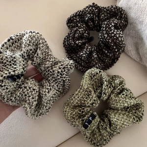 Detailed texture of three tweed scrunchies in grey, coffee and green for autumn