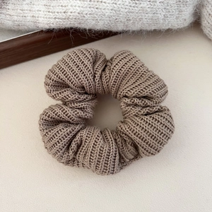 Détail d'un chouchou en maille marron café montrant la texture en spirale pour l'automne