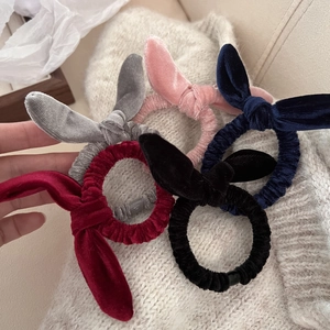 Lot de 5 chouchous en velours à oreilles de lapin sur un fond de pull en maille douce