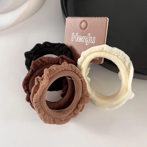 Detail of 4-pack ruffled hair ties in neutral colors on a premium display card