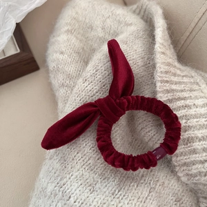 Chouchou élégant en velours bordeaux avec oreilles de lapin sur fond en tricot beige