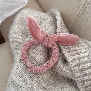 Détail macro du chouchou en velours rose doux avec un nœud en oreilles de lapin