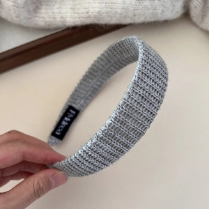 Gros plan du bandeau en tricot gris avec texture épaisse et étiquette tissée interne