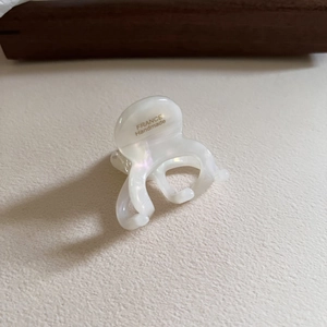 Gros plan sur la pince à cheveux en acétate blanc avec gravure dorée France Handmade