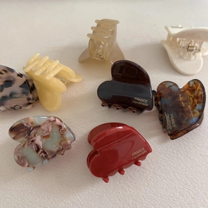Various acetate heart-shaped hair claw clips in leopard, marble, and amber patterns