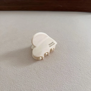 Detail of cream heart hair clip showing France Handmade engraving and acetate texture