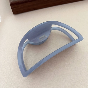 Dettaglio ravvicinato della molletta blu opaca con logo dorato France Handmade