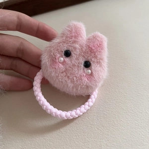 Nahaufnahme von rosa Plüsch-Kaninchen-Haargummi mit Ohren und elastischem Webband-Detail
