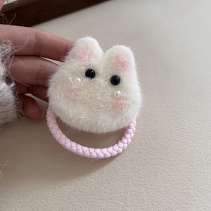 Nahaufnahme eines flauschigen Kaninchen-Haargummis mit Perlen und rosa Gummiband