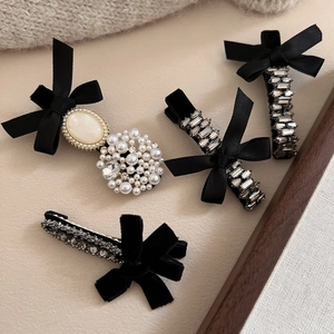 French vintage hair clip set with black bows pearls and rhinestones on beige fabric