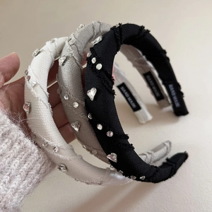 Macro shot of rhinestone heart headbands showing hand made label and non-slip lining