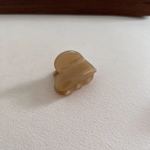 Detail of amber heart-shaped acetate hair clip with golden France Handmade engraving