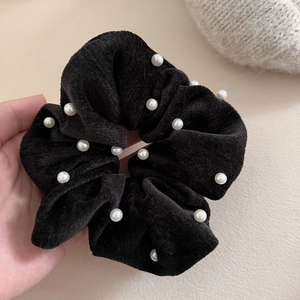 Detail of vintage black velvet scrunchie with elegant faux pearl embellishments