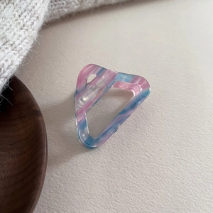 Détail de la pince à cheveux triangle en acétate marbré rose et bleu avec logo Handmade