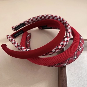 Dettaglio di cerchietti in velluto rosso e scozzesi con trame tessili fatte a mano