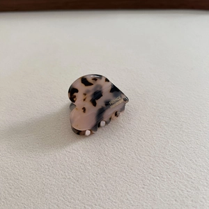 Close-up of tortoise shell acetate heart hair claw with gold France Handmade logo