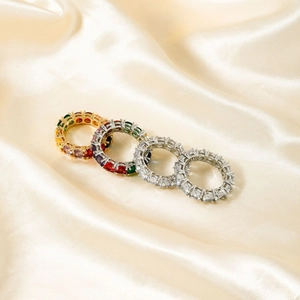 Exquisite copper eternity rings with multicolor cubic zirconia on silk satin background