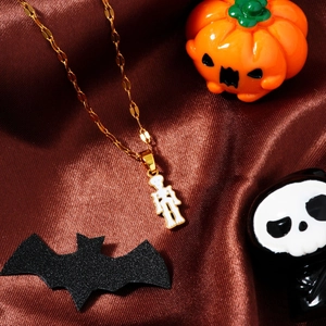 Golden Halloween necklace with white enamel skull pendant on a silk background