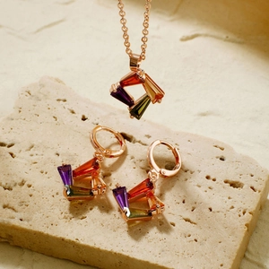 Detailaufnahme des Regenbogen-Schmucksets mit Roségold-Anhängern auf Steinbasis