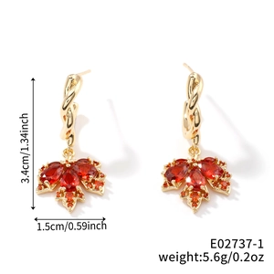 Vista detallada de pendientes de hoja de arce con circonitas rojas y medida 3,4 cm