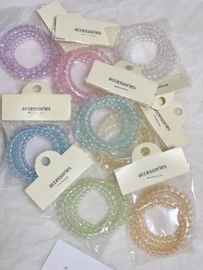Dettaglio di elastici a spirale colorati in confezione singola con cartellini per accessori
