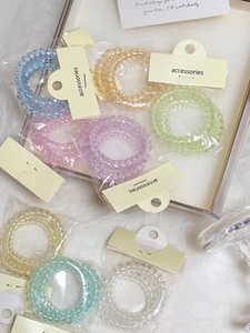 Dettaglio di elastici a spirale color macaron con confezione individuale in carta