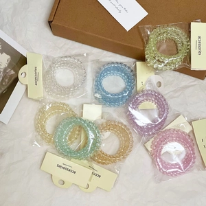 Dettaglio degli elastici per capelli a spirale in vari colori macaron e confezione