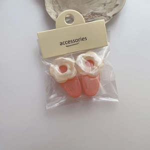 Détail de pinces à cheveux à fleurs mignonnes avec petites fleurs crème en emballage