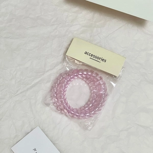 Dettaglio degli elastici per capelli a spirale rosa trasparente nella confezione