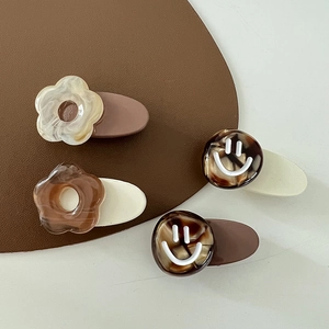 Set of four milk coffee colored floral hair clips with smiley patterns on smooth acrylic