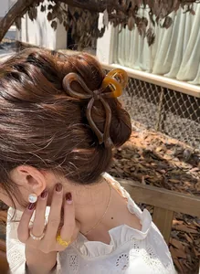 Elegante molletta a fiocco color ambra acconciata su uno chignon classico basso