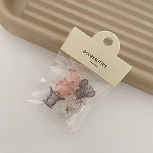 Set of 6 mini hair claw clips in pink, grey and clear resin shown on card packaging