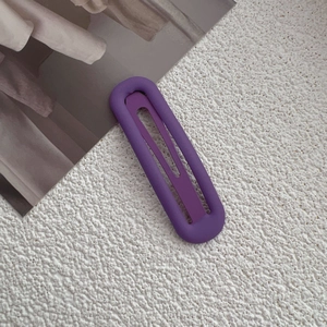Close-up of matte purple rectangular hollow hair clip with elegant frosted texture