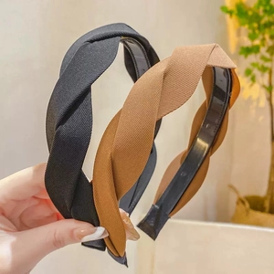 Detail view of French retro twisted headbands in black and tan ribbed fabric texture