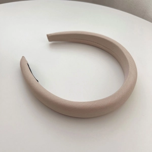 Detail view of wide sponge headband in light beige fabric with anti-slip black lining